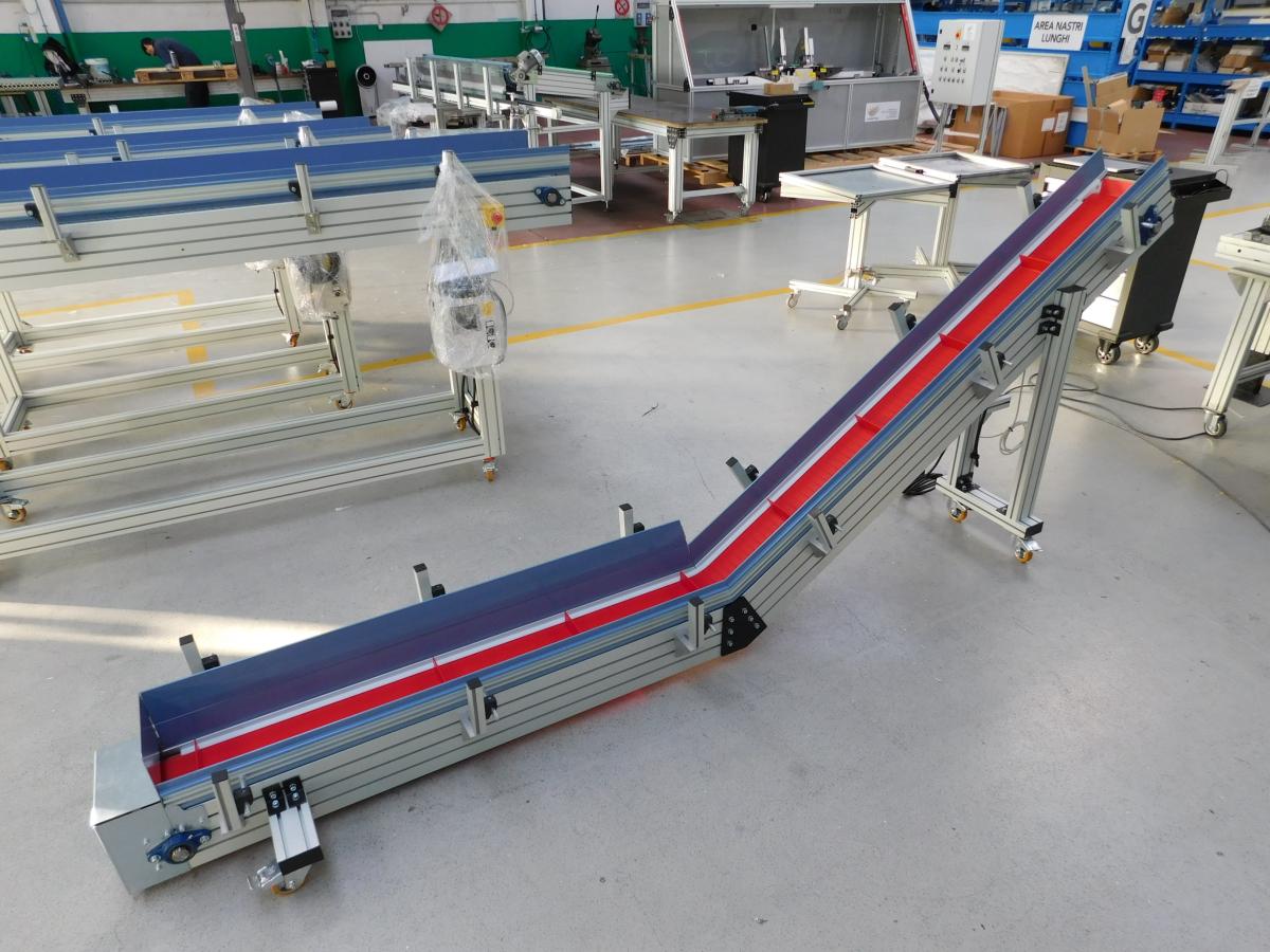 Fodo di un nastro trasportatore modulare a maglia plastica con struttura in profilo di alluminio inclinato